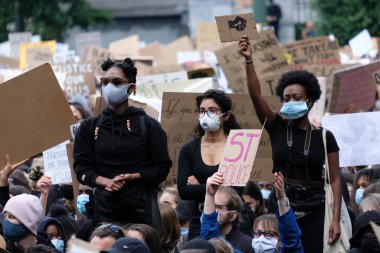 George Floyd 'un Brüksel, Belçika' da öldürülmesinin ardından ırkçılık karşıtı bir protesto sırasında protestocular yumruklarını kaldırdılar. 7, 2020.