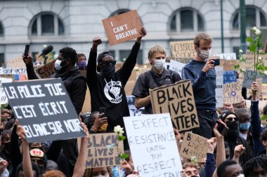 George Floyd 'un Brüksel, Belçika' da öldürülmesinin ardından ırkçılık karşıtı bir protesto sırasında protestocular yumruklarını kaldırdılar. 7, 2020.