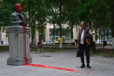 İnsanlar 12 Haziran 2020 Cuma günü Brüksel 'de eski Belçika Kralı Baudouin' in yağmalanıp kırmızı boyayla boyandığı büstün önünden geçtiler. Heykelin kırmızı boya vandalizmi Brüksel 'deki ırkçılık karşıtı gösterilerin bir kısmını oluşturuyor.