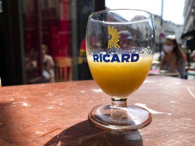 Brüksel 'de, Belçika' da, Brüksel 'de ahşap bir masada pastis, anason ve meyan kökü aromalı aperatif olan bir bardak Ricard. 15, 2020