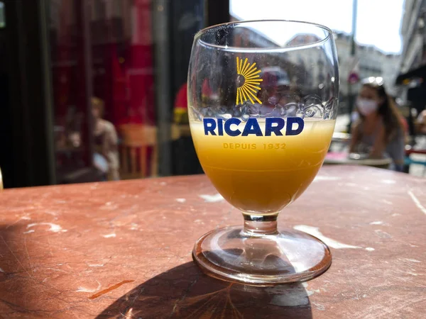 Brüksel 'de, Belçika' da, Brüksel 'de ahşap bir masada pastis, anason ve meyan kökü aromalı aperatif olan bir bardak Ricard. 15, 2020