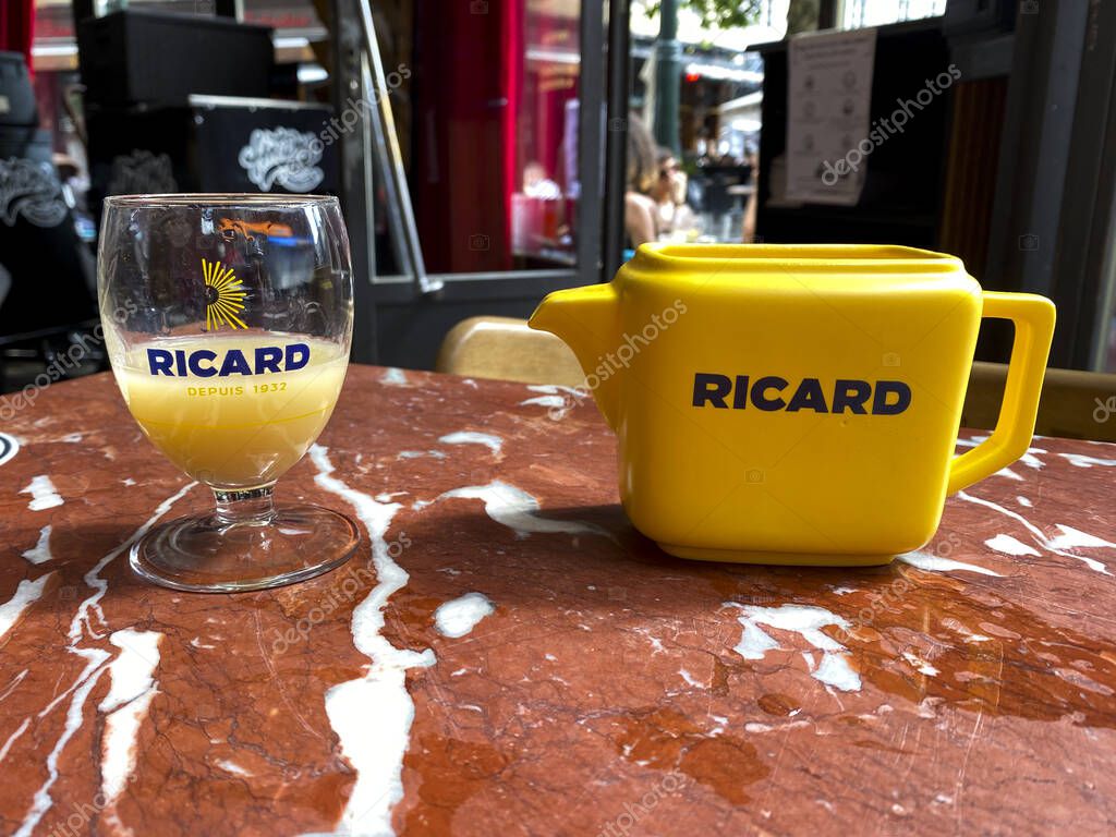 A glass of Ricard which is a pastis, an anise and licorice-flavored aperitif in wooden table in Brussels, Belgium on Jun. 15, 2020
