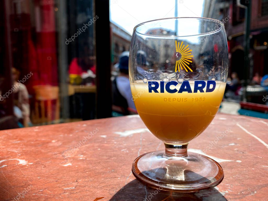 A glass of Ricard which is a pastis, an anise and licorice-flavored aperitif in wooden table in Brussels, Belgium on Jun. 15, 2020