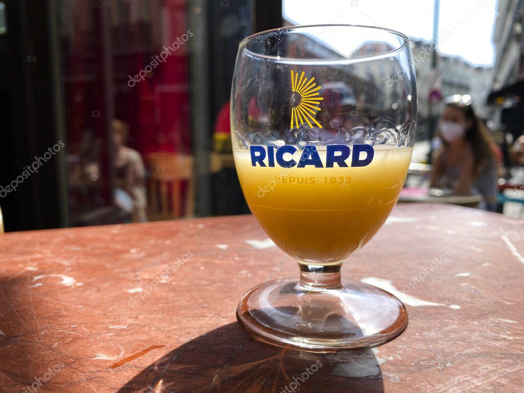 A glass of Ricard which is a pastis, an anise and licorice-flavored aperitif in wooden table in Brussels, Belgium on Jun. 15, 2020