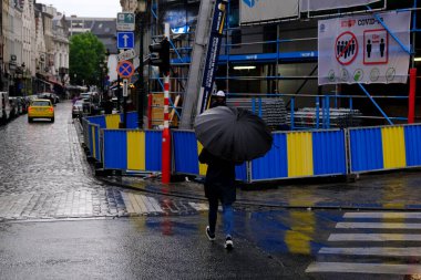 Belçika 'da 17 Haziran 2020' de meydana gelen yaz fırtınası sırasında insanlar Brüksel 'in merkezinde yürüyorlar..