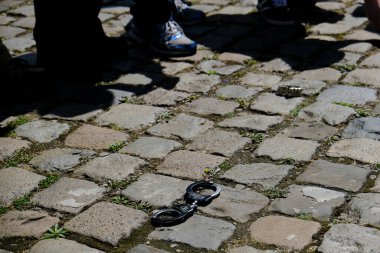 Brüksel, Belçika. 19 Haziran 2020. Polis memurları tarafından yerde bırakılan kelepçeler, polise karşı düzenlenen bir protesto şiddet eylemi ve medyada polis karşıtı algılanan bir tavır sırasında resmedildi.