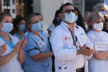 Brüksel, Belçika. 23 Haziran 2020. Ixelles Hastanesi 'nde daha iyi çalışma koşulları çağrısında bulunan bir protestoya sağlık çalışanları da katıldı..
