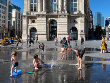 Brüksel, Belçika. 25 Haziran 2020. İnsanlar sıcak bir yaz gününde merkez meydandaki çeşmelerde serinlerler..