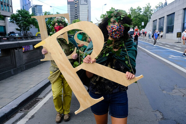 Брюссель, Бельгия 27 июня 2020 года. Активисты держат буквы, образующие слово: "Устойчивость" рядом с полицейской линией безопасности во время протеста активистов движения "Восстание против вымирания"
.