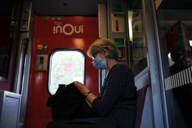 Bir yolcu, Fransa 'nın Lille şehrinde haziran ayında trende koruyucu yüz maskesi takıyor. 28, 2020