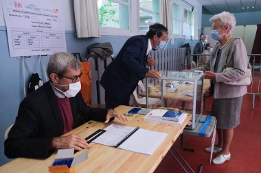Voters cast their ballot  in a polling station during the second round of the French Municipal elections in Lille, France on June, 28th 2020 clipart