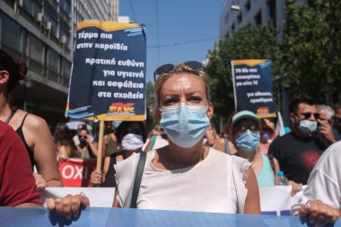 Yüz maskesi takan öğretmenler, 25 Ağustos 2020 'de Yunanistan' ın Atina kentinde yapılacak yeni öğrenim yılı öncesinde okulların güvenli bir şekilde açılması yönünde tedbirler alınmasını talep eden bir protestoya katıldılar..