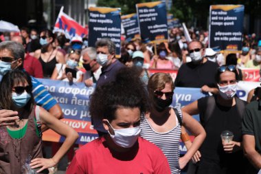 Yüz maskesi takan öğretmenler, 25 Ağustos 2020 'de Yunanistan' ın Atina kentinde yapılacak yeni öğrenim yılı öncesinde okulların güvenli bir şekilde açılması yönünde tedbirler alınmasını talep eden bir protestoya katıldılar..