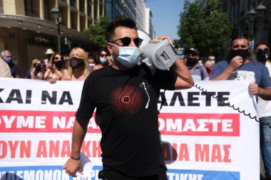 Yüz maskesi takan öğretmenler, 25 Ağustos 2020 'de Yunanistan' ın Atina kentinde yapılacak yeni öğrenim yılı öncesinde okulların güvenli bir şekilde açılması yönünde tedbirler alınmasını talep eden bir protestoya katıldılar..