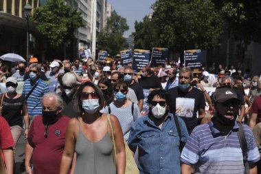 Yüz maskesi takan öğretmenler, 25 Ağustos 2020 'de Yunanistan' ın Atina kentinde yapılacak yeni öğrenim yılı öncesinde okulların güvenli bir şekilde açılması yönünde tedbirler alınmasını talep eden bir protestoya katıldılar..