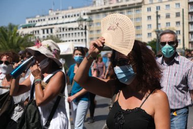 Yüz maskesi takan öğretmenler, 25 Ağustos 2020 'de Yunanistan' ın Atina kentinde yapılacak yeni öğrenim yılı öncesinde okulların güvenli bir şekilde açılması yönünde tedbirler alınmasını talep eden bir protestoya katıldılar..