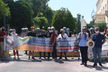Yüz maskesi takan öğretmenler, 25 Ağustos 2020 'de Yunanistan' ın Atina kentinde yapılacak yeni öğrenim yılı öncesinde okulların güvenli bir şekilde açılması yönünde tedbirler alınmasını talep eden bir protestoya katıldılar..