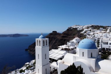 Yunanistan 'ın Santorini adasındaki Thira kasabasındaki geleneksel beyaz saray ve kiliselerin hava manzarası. Thira, Santorini 15 Ağustos 2020
