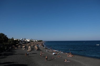 İnsanlar 12 Ağustos 2020 'de Yunanistan' ın Santorini kentindeki Kamari Plajı 'nda dinleniyorlar.