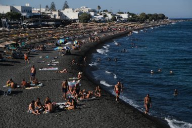 İnsanlar 12 Ağustos 2020 'de Yunanistan' ın Santorini kentindeki Kamari Plajı 'nda dinleniyorlar.