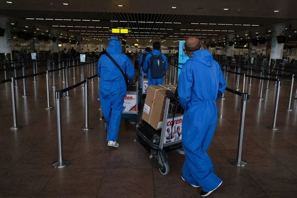 Koronavirüsün yayılmasını önlemek için maske takan yolcular, 24 Temmuz 2020 'de Brüksel, Belçika' daki Zaventem uluslararası havaalanındaki panoya bakın.