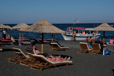 İnsanlar 12 Ağustos 2020 'de Yunanistan' ın Santorini kentindeki Kamari Plajı 'nda dinleniyorlar.