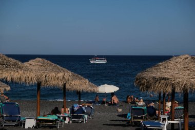 İnsanlar 12 Ağustos 2020 'de Yunanistan' ın Santorini kentindeki Kamari Plajı 'nda dinleniyorlar.