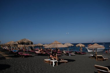 İnsanlar 12 Ağustos 2020 'de Yunanistan' ın Santorini kentindeki Kamari Plajı 'nda dinleniyorlar.