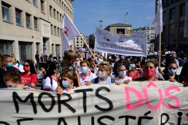 Belçika, Brüksel 'de 13 Eylül 2020' de düzenlenen bir Sağlık Bölgesi protestosu sırasında yüz maskesi takan insanlar pankart taşıyorlar..