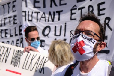 Belçika, Brüksel 'de 13 Eylül 2020' de düzenlenen bir Sağlık Bölgesi protestosu sırasında yüz maskesi takan insanlar pankart taşıyorlar..
