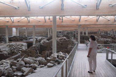 Ziyaretçiler, tarih öncesi Akrotiri kentinde MÖ 1500 yılına kadar yaşamış olan ve yıkıcı bir patlamanın her şeyi yok ettiği bir geziye çıkıyorlar. Santorini, Yunanistan, 17 Ağustos 2020