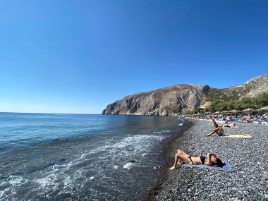 19 Ağustos 2020 'de Yunanistan' ın Kamari plajında yüzücüler güneşleniyor.