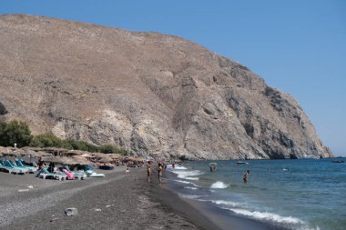 İnsanlar 13 Ağustos 2020 'de Yunanistan' ın Santorini kentinde Perissa plajında güneşli bir gün ve denizin keyfini çıkarıyorlar..