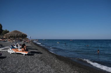 İnsanlar 12 Ağustos 2020 'de Yunanistan' ın Santorini kentindeki Kamari Plajı 'nda dinleniyorlar..