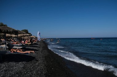 İnsanlar 12 Ağustos 2020 'de Yunanistan' ın Santorini kentindeki Kamari Plajı 'nda dinleniyorlar..