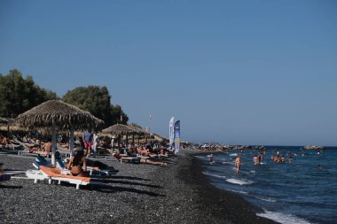 İnsanlar 12 Ağustos 2020 'de Yunanistan' ın Santorini kentindeki Kamari Plajı 'nda dinleniyorlar..