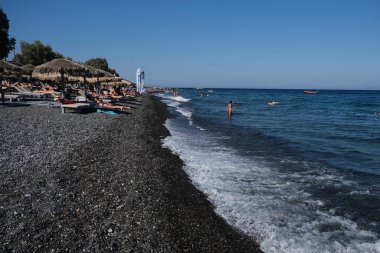 İnsanlar 12 Ağustos 2020 'de Yunanistan' ın Santorini kentindeki Kamari Plajı 'nda dinleniyorlar..
