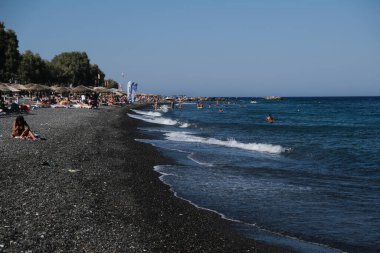 İnsanlar 12 Ağustos 2020 'de Yunanistan' ın Santorini kentindeki Kamari Plajı 'nda dinleniyorlar..