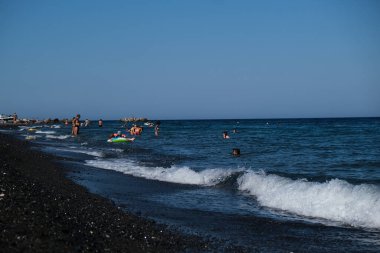 İnsanlar 12 Ağustos 2020 'de Yunanistan' ın Santorini kentindeki Kamari Plajı 'nda dinleniyorlar..