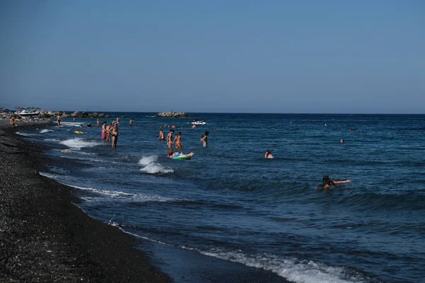 İnsanlar 12 Ağustos 2020 'de Yunanistan' ın Santorini kentindeki Kamari Plajı 'nda dinleniyorlar..
