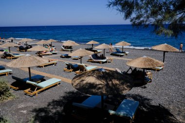 Santorini, Yunanistan, 12 Ağustos 2020. Covid-19 Corona yüzünden plajda turist olmayan boş koltuklar..