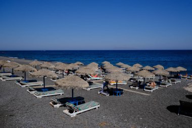 Santorini, Yunanistan, 12 Ağustos 2020. Covid-19 Corona yüzünden plajda turist olmayan boş koltuklar..