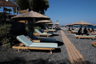 Santorini, Yunanistan, 12 Ağustos 2020. Covid-19 Corona yüzünden plajda turist olmayan boş koltuklar..