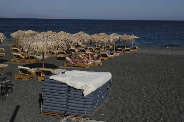 Santorini, Yunanistan, 12 Ağustos 2020. Covid-19 Corona yüzünden plajda turist olmayan boş koltuklar..