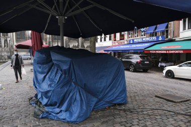 Brüksel, Belçika. 8 Ekim 20.Yüz maskesi takan bir yaya kapalı bir kafenin önünden geçiyor. Ülkedeki koronavirüs hastalığının artmasından sonra bütün barlar ve kafeler kapalı kalmalı.