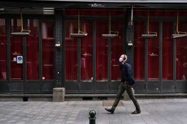Brüksel, Belçika. 8 Ekim 20.Yüz maskesi takan bir yaya kapalı bir kafenin önünden geçiyor. Ülkedeki koronavirüs hastalığının artmasından sonra bütün barlar ve kafeler kapalı kalmalı.