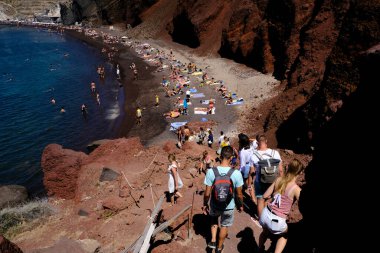 İnsanlar 14 Ağustos 2020 'de Yunanistan' ın Santorini adasındaki Kızıl Sahilde yüzerken güneşli havanın tadını çıkarıyorlar.