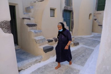 14 Ağustos 2020 'de Yunanistan' da Emporio caddesinde maske takan yaşlı bir kadın yürüyor.