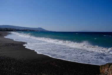 Santorini Yunan adasında kumlu bir sahilde dalgalar