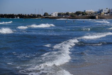 Yunanistan 'ın Santorini adasında insanlar 18 Ağustos 2020' de dalga denizinde yüzerler.